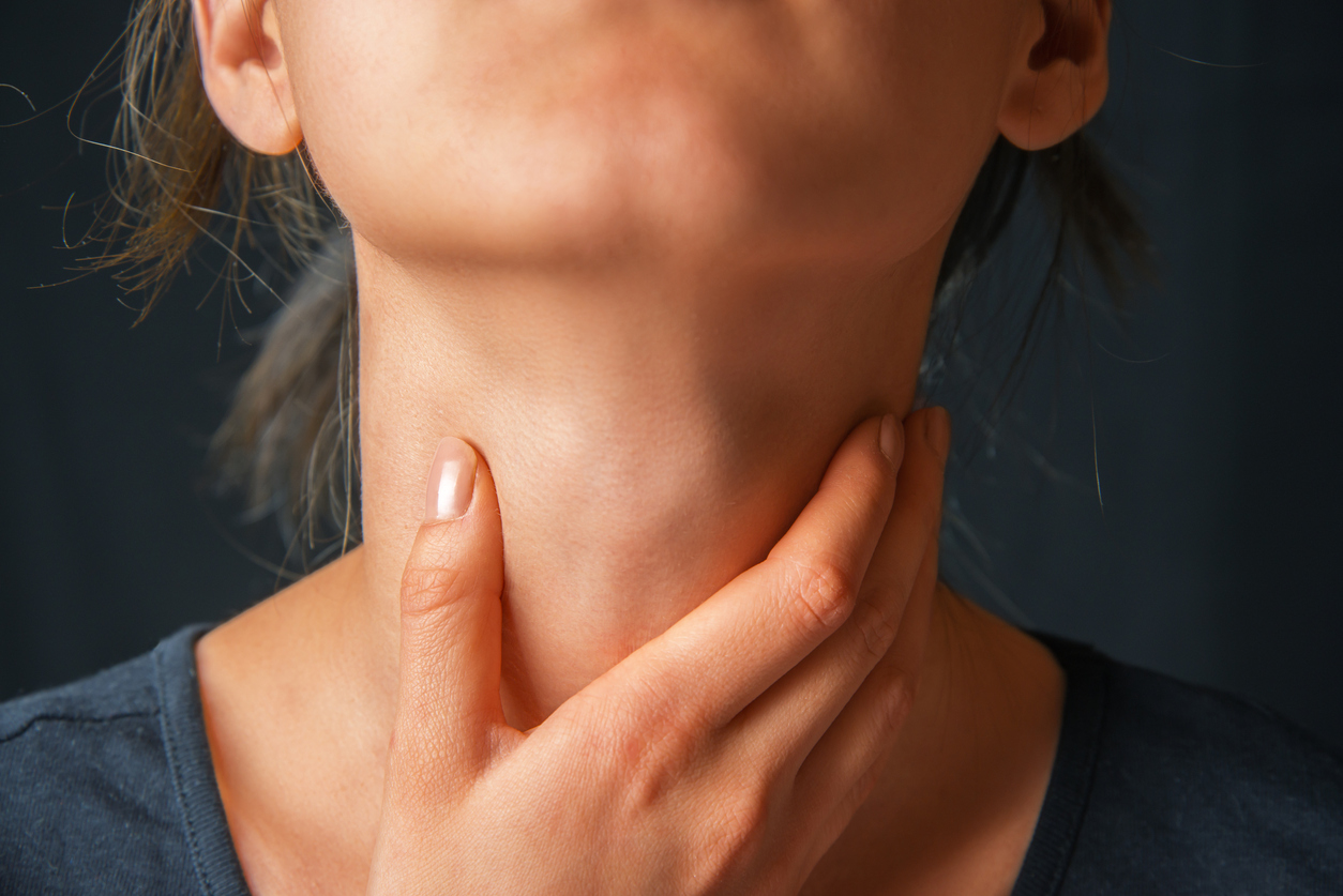 Woman holds her throat, sore throat