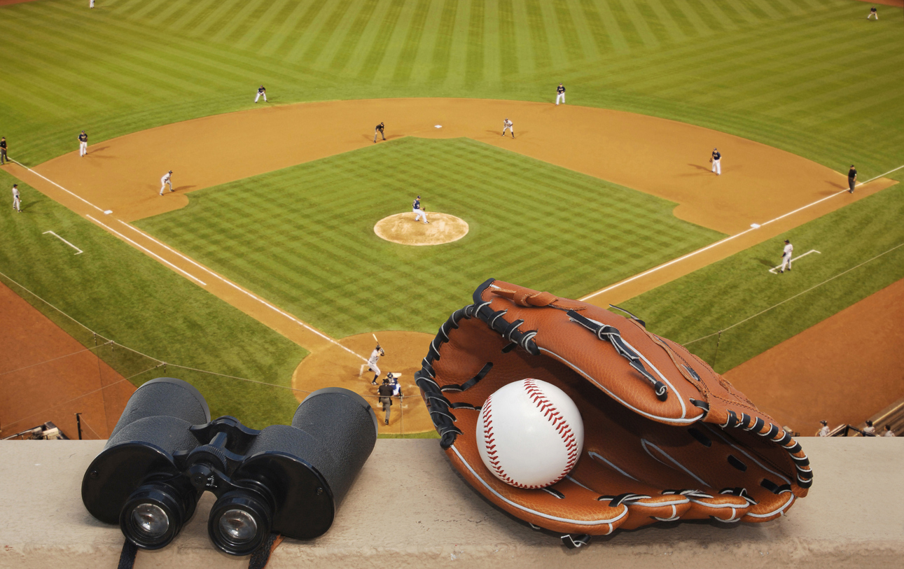 Binoculars and a baseball glove at a ballpark